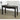 Black desk with a laptop, mouse, and stationery on a wooden floor.
