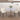 Round dining table with marble top and four white chairs in a room with wooden flooring and white walls.